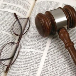 gavel and glasses placed on top of legal book