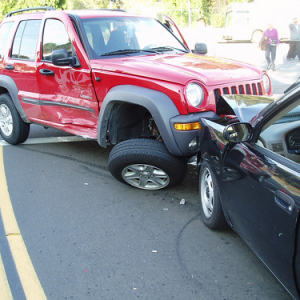 red jeep crashed into the front of a black vehicle