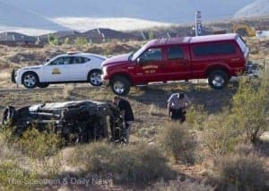 car rolled over on side of road with police assisting