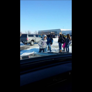 school children gathered in snowy parking lot